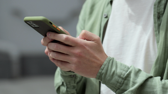 Person som følger opp kunder med SMS og e-post på mobilen